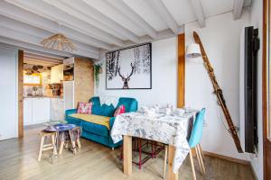 a living room with a blue couch and a table at Les Alysses - Maison pour 5 avec garage in Font-Romeu