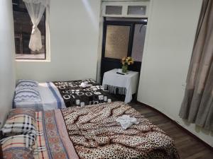 a bedroom with a bed and a table and a window at Nuevo Hostal Victoria in Quito