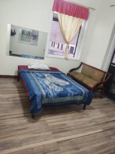 a bedroom with a bed and a chair and a window at Nuevo Hostal Victoria in Quito