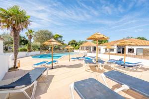 a swimming pool with lounge chairs and umbrellas at Camping Paradis 4 étoiles A La Corniche La Rochelle Angoulins in Angoulins-sur-Mer