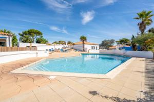 a swimming pool in the middle of a patio with a blue sky at Camping Paradis 4 étoiles A La Corniche La Rochelle Angoulins in Angoulins-sur-Mer