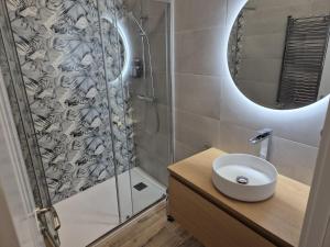 a bathroom with a shower with a sink and a mirror at Casa La tranca in Cuevas del Valle
