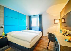 a hotel room with a bed and a desk at Travelinjoy in Rietheim-Weilheim