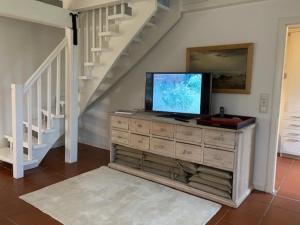 sala de estar con TV en un vestidor con escalera en Traumstraße Bollis Huis 2, en Nieblum