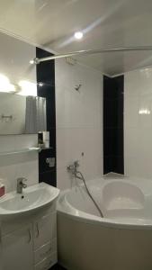 a bathroom with a bath tub and a sink at Cozy and comfortable apartment in Cherkasy
