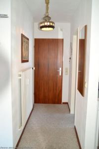 a hallway with a wooden door and a hallwayngth at Wiesenweg - Wohnung 06 in Wyk auf Föhr