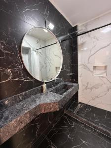 a bathroom with a large mirror and a sink at Aloha II in Rosario