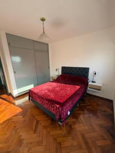 a bedroom with a bed with a red comforter at Aloha II in Rosario