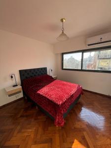 a bedroom with a bed with a red comforter at Aloha II in Rosario