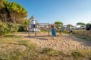 a park with a playground with people playing on it at Camping Paradis 4 étoiles A La Corniche La Rochelle Angoulins in Angoulins-sur-Mer
