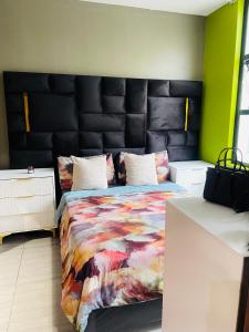 a bedroom with a large bed with a black headboard at Feel at home in Durban