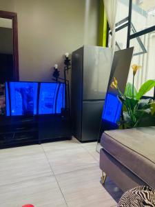 a living room with two flat screen televisions at Feel at home in Durban