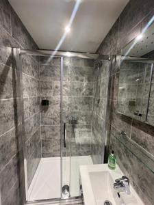 a bathroom with a shower and a sink and a tub at The Plough Itchen Abbas in Winchester +107 photos