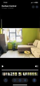 a living room with a couch and a green wall at Feel at home in Durban