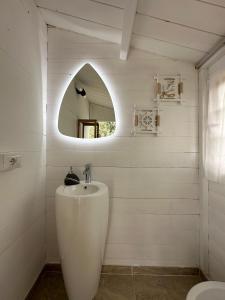 Un baño blanco con lavabo y espejo. en Casa vacanza Lentisco D Sardegna Ogliastra, en Tertenìa 47 fotos más