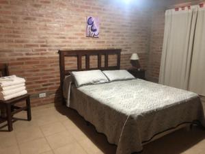 a bedroom with a bed and a brick wall at Complejo La Morena in Mina Clavero +34 photos