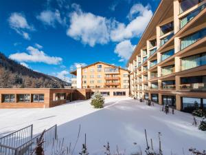 a snow covered courtyard in front of a building at Hotel Palü in Pontresina