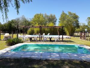 a pool with a table and chairs and a picnic table at Complejo La Morena in Mina Clavero