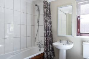 a bathroom with a sink and a bath tub and a mirror at Wild Oats Lodge 2, Yellowtop Country Park in Selby +5 photos