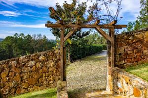 an entrance to a stone wall with a wooden gate at Quinta da Gala Countryhouse in Arouca