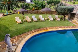 a group of chairs and umbrellas next to a swimming pool at Quinta da Gala Countryhouse in Arouca +46 photos