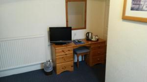 a bedroom with a desk with a television on it at Ashwood Hotel in Preston