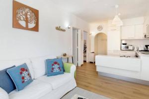 a living room with a white couch and a kitchen at Lomba House, Almoçageme in Colares