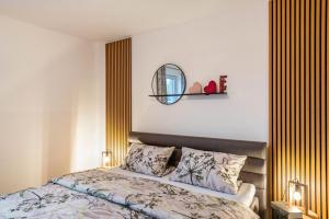 ein Schlafzimmer mit einem Bett und einem Spiegel an der Wand in der Unterkunft Domizil Eden - Erdgeschoss in Göhren-Lebbin