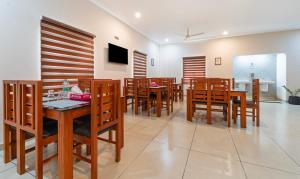 a dining room with wooden tables and chairs at Treebo Thoduvas Star Plaza Cochin Airport in Nedumbassery