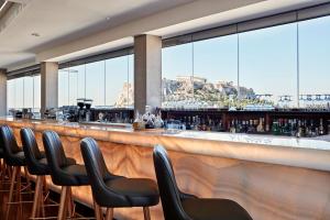 a bar with chairs and a view of the mountain at Electra Metropolis in Athens