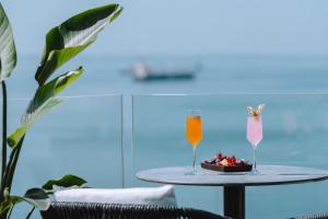 a table with a bowl of fruit and two drinks at Electra Palace Thessaloniki in Thessaloniki