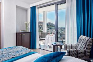a hotel room with a bed and a view of the city at Electra Metropolis in Athens
