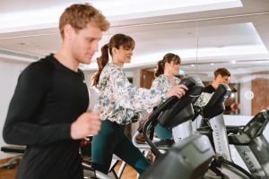 a man and woman exercising on cardio bikes in a gym at Electra Metropolis in Athens