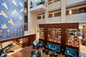 a library with blue chairs and books at Electra Metropolis in Athens