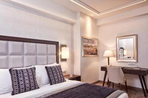 a hotel room with a bed and a desk at Electra Metropolis in Athens