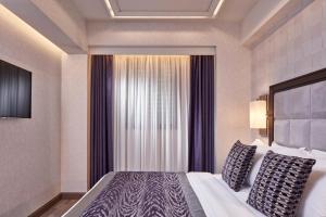 a hotel room with a bed and a window at Electra Metropolis in Athens