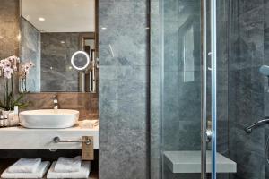 a bathroom with a sink and a shower at Electra Metropolis in Athens