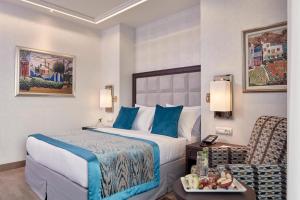 a hotel room with a bed and a chair at Electra Metropolis in Athens