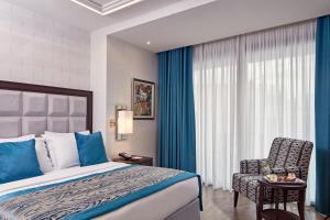 a hotel room with a bed and a chair at Electra Metropolis in Athens