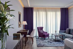 a living room with a purple chair and a couch at Electra Metropolis in Athens