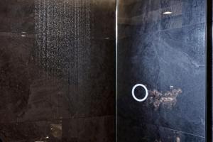 a shower with a glass door with a shower head at Electra Metropolis in Athens
