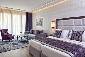 a hotel room with a large bed and a living room at Electra Metropolis in Athens