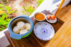 a tray of food with cookies and a bowl of dipping sauce at Marari Eden Castle in Vayalār