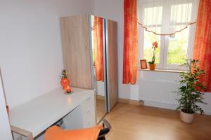 um quarto com uma secretária branca e uma janela em Im Kuckucksnest em Chemnitz