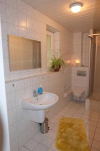 La salle de bains blanche est pourvue d'un lavabo et de toilettes. dans l'établissement Im Kuckucksnest, à Chemnitz