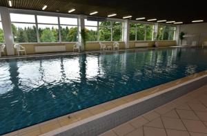 a large swimming pool with chairs in a building at Hohegeiß-Braunlage-Apartment 374 in Braunlage