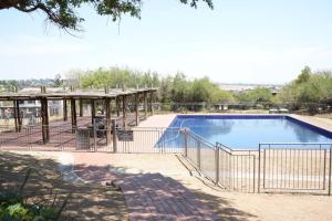 a large swimming pool with a fence around it at Modern Penthouse in Roodepoort