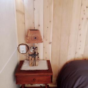 Un dormitorio con una mesa con una lámpara. en Cabaña El Carpintero, en El Chaltén