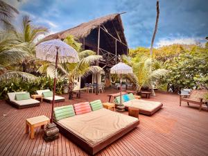 a patio with couches and tables and umbrellas at Isla Única- Islas del Rosario in Isla Grande