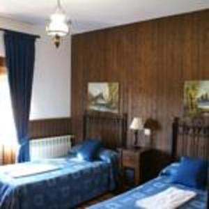 a bedroom with two beds with blue pillows at Casa Rural Peña Falcón in Torrejón el Rubio
